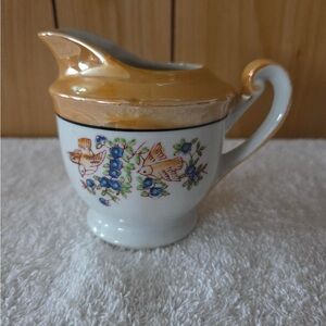 vintage Noritake lusterware creamer with a hand-painted floral and bird pattern